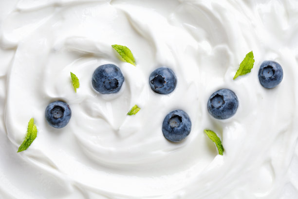 酸奶加蓝莓和薄荷，配上冰淇淋。美味的液体质地的白色酸奶油与蓝莓。奶油乳制品。图片下载