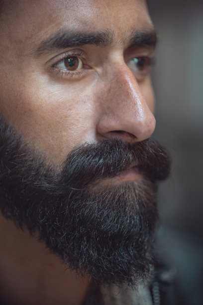 大胡子望向别处，沉思着。图片下载