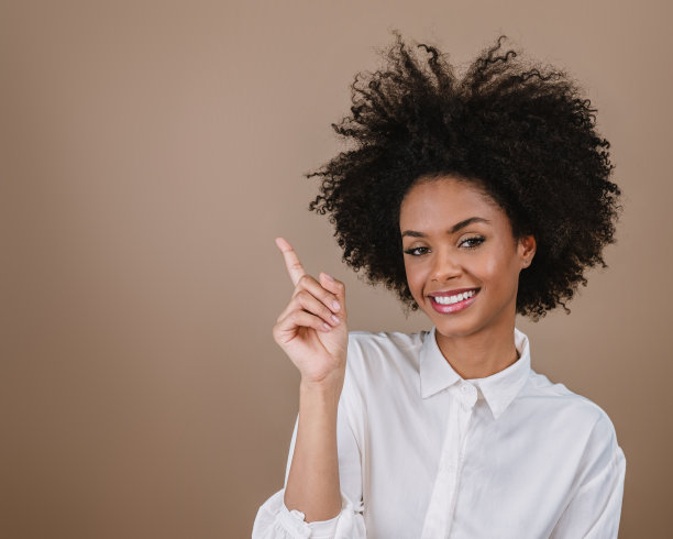 一个年轻的拉丁女孩指着两边。广告和呈现概念。柔和的背景。图片下载