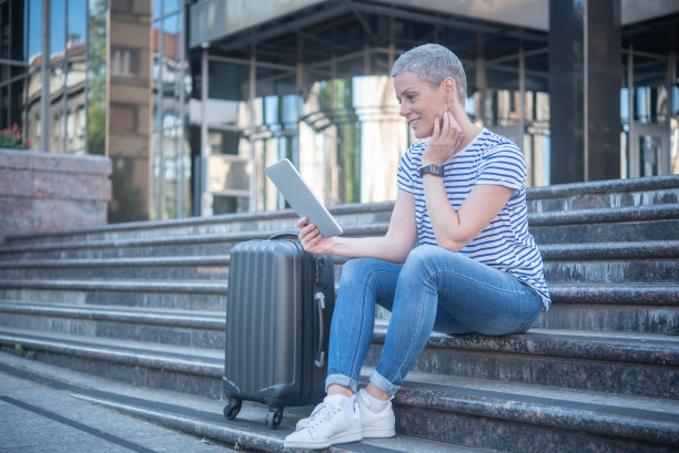 中年妇女提着行李箱图片下载