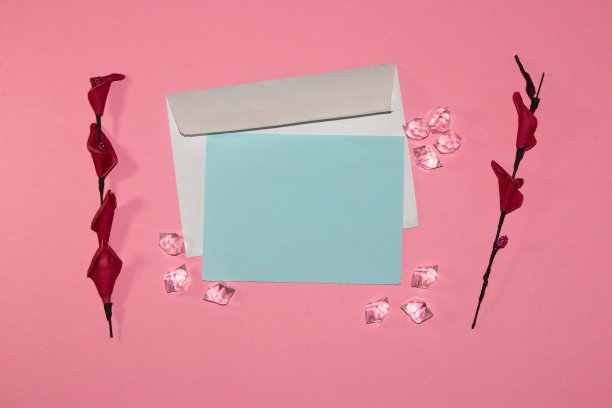 字母以蓝色纸为复制空间，围绕宝石和花朵在粉红色的背景，创意浪漫的艺术设计图片下载