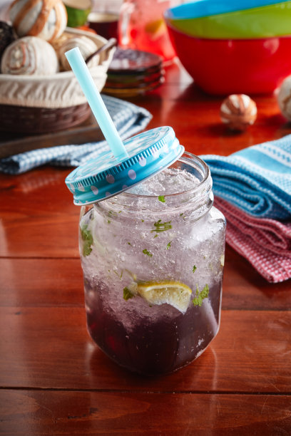 一杯健康新鲜的蓝莓苏打饮料与冰和稻草隔离在木制背景侧视图图片下载