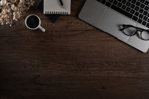 简单的工作场所，笔记本电脑，眼镜，咖啡杯和记事本。带有拷贝空间的俯视图。图片下载