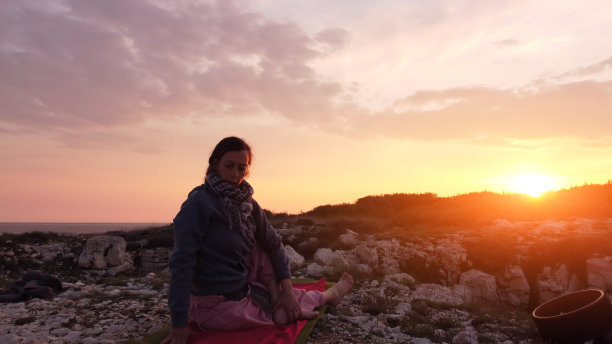 在日落日出的时间练习瑜伽的女人。图片下载