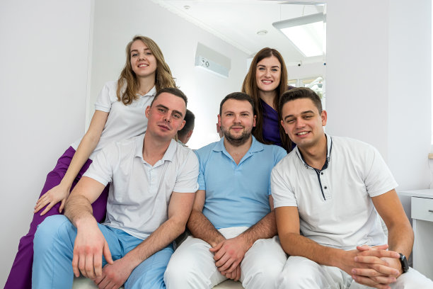 五个年轻有为、经验丰富的牙医大师在走廊里摆姿势。图片下载