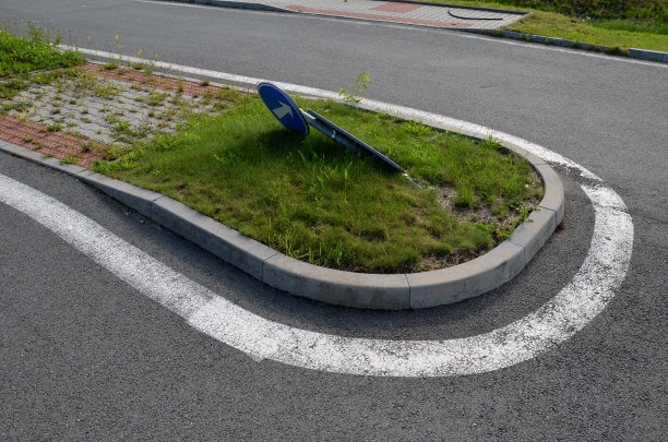 在杂草丛生的十字路口，水泥方块组成的人行道。没有定期维护的社区。难以通过的人行道需要用割草机修剪。图片下载