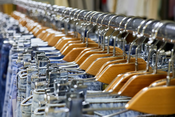 服装店的衣架上挂着各种蓝色牛仔裤。特写,有选择性的重点图片下载