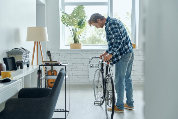 兴高采烈的年轻人在检查他的自行车图片下载