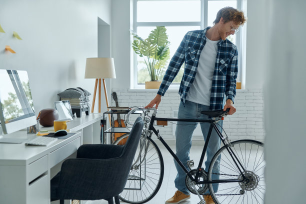 自信的年轻人检查他的自行车图片下载