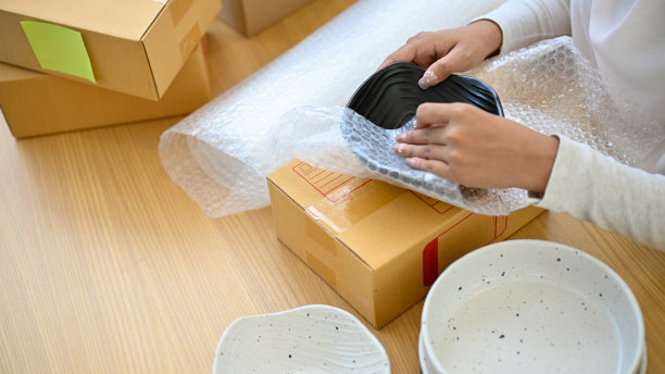 一个女性小企业企业家正在把她的厨具产品装进一个纸盒里图片下载