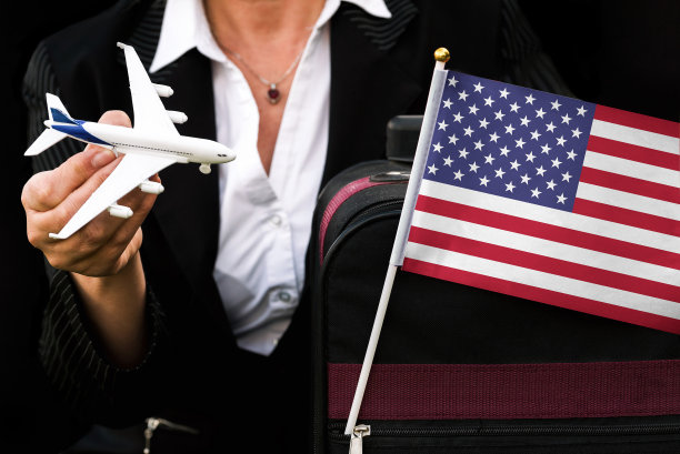 女商人拿着玩具飞机旅行袋和美国国旗图片下载