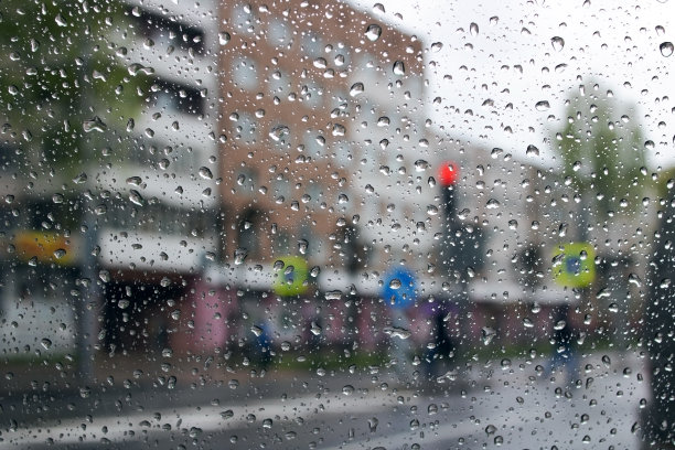 雨点落在挡风玻璃上的城市道路背景图片下载