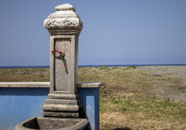 意大利阳光明媚的卡拉布里亚海滩上的老式水龙头。海边的自来水。阳光明媚的日子里，海滩上的淡水水龙头。图片下载