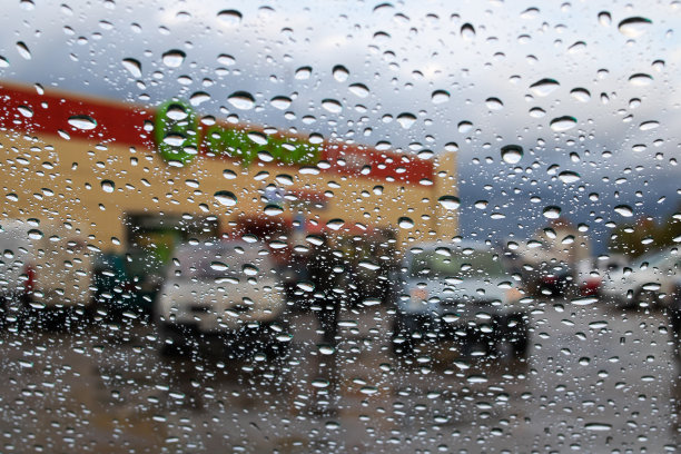 雨点落在挡风玻璃上的城市道路背景图片下载