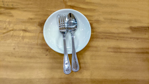 白盘子勺子和叉子放在木桌上图片下载