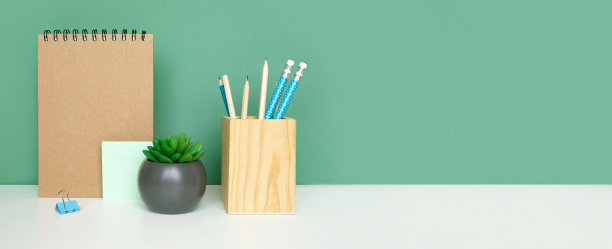 学校设备上白色的桌子，绿色的墙壁背景。教育背景。木制的学校用品，笔记本，铅笔和仙人掌植物。回到学校。学生的桌子上。文具进行研究。在家里工作图片下载