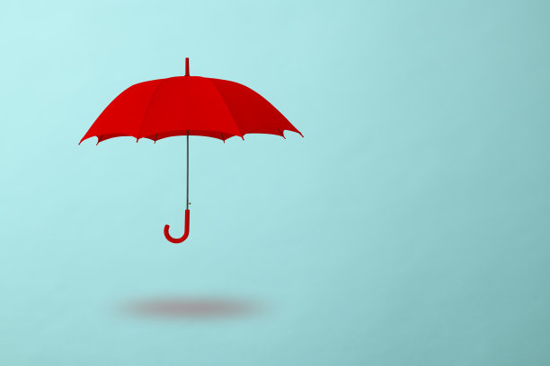 红色的伞在浅蓝色的背景下漂浮在半空中图片下载