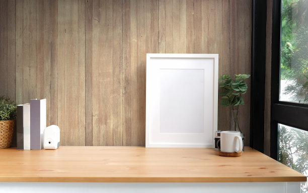 家庭创意工作空间与空白的海报框架，相机，咖啡杯和木桌子上的室内植物。“t图片下载