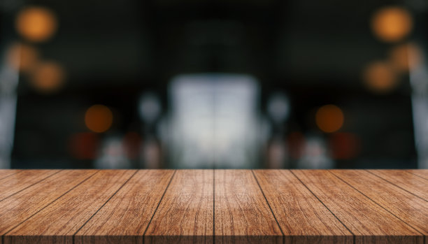 空的木制桌面与灯光散焦模糊的餐厅背景。图片下载