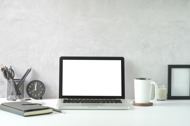 现代工作场所的笔记本电脑，咖啡杯，笔记本和笔筒在白色的桌子。图片下载