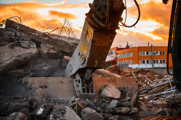 现代破碎机上的挖掘机索具拆除混凝土梁图片下载