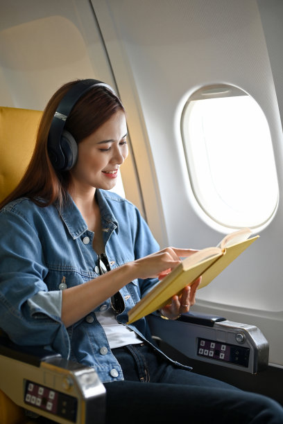 迷人的亚洲女乘客放松听音乐耳机和读书图片下载