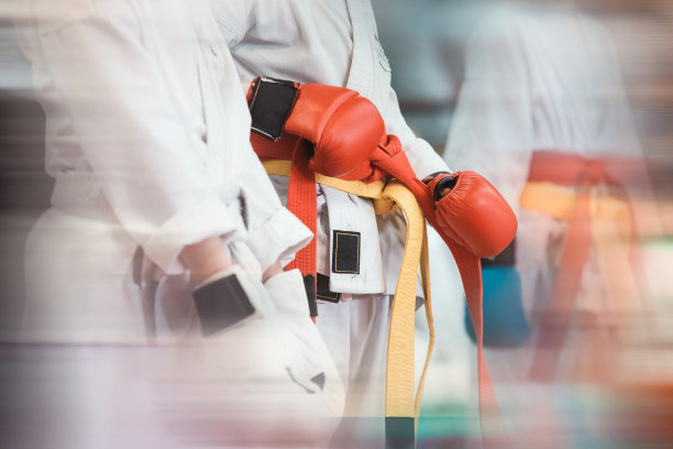 一名戴着红色手套的空手道运动员在比赛前系好腰带。图片下载