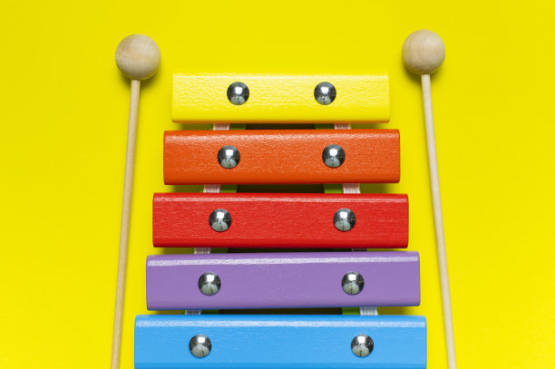 彩色木制木琴和震动棒在明亮的黄色背景平铺俯视拷贝空间。木制儿童音乐玩具婴儿乐器彩虹的颜色。儿童天然生态玩具图片下载