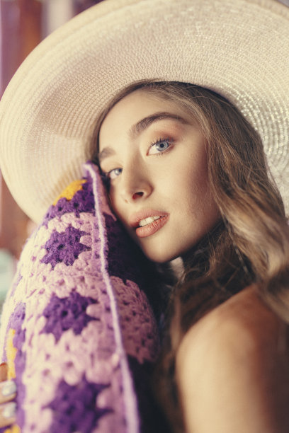 金发女郎拿着紫色枕头图片下载