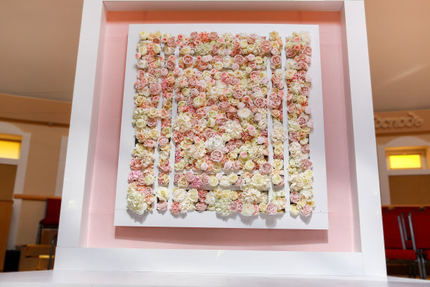 举行婚礼的地点。婚礼用的方形拱门用粉白玫瑰和牡丹花装饰。宴会区域内的婚礼装饰。图片下载