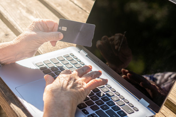 女性双手捧着信用卡笔记本电脑后台公园图片下载