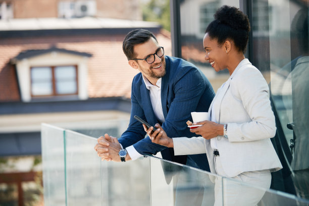 愉快的商务同事在阳台上喝咖啡休息。图片下载