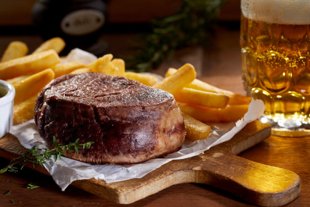美味的菲力牛排配炸薯条，再配上一罐啤酒图片下载