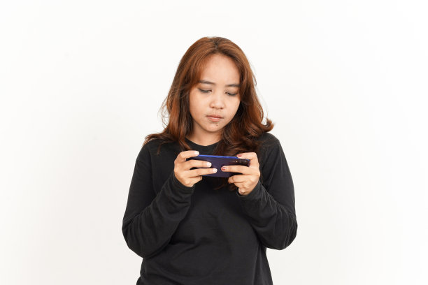 在智能手机上玩漂亮的亚洲女人穿黑色衬衫孤立在白色的手机游戏图片下载
