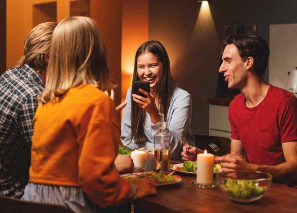女人在看手机短信或给朋友看有趣的照片时开心地笑图片下载