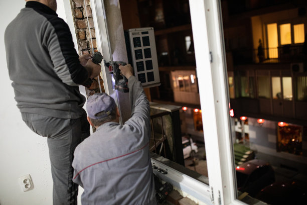 穿着工作服的专业工人安装窗户图片下载