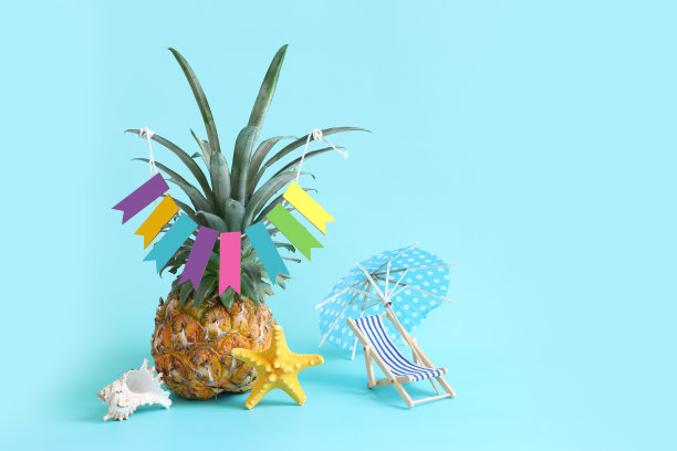 图片与成熟的菠萝伞和蓝色背景的沙滩椅。暑假和热带主题图片下载