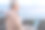 年老的活跃的女人坐在卵石滩上使用笔记本电脑远程工作。成熟的女性在海上享受日落，膝上拿着笔记本电脑，水面上的地平线图片下载