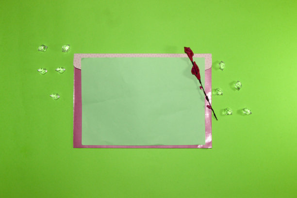 柔和的绿色信封纸在绿色的背景与鲜花和宝石，创意现代艺术设计，邀请图片下载