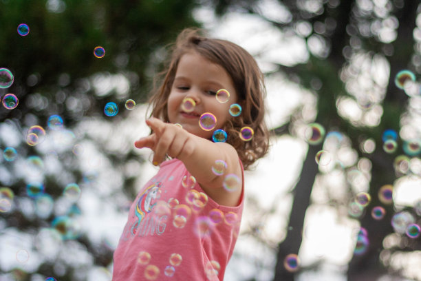 孩子试图用手指击打泡泡。图片下载