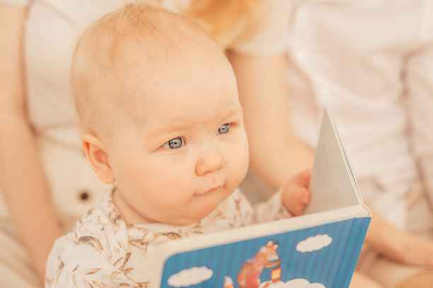 可爱的肖像严肃的灰色眼睛丰满的娃娃脸婴儿婴儿蹒跚学步穿着米黄色的紧身衣与图案坐。图片下载