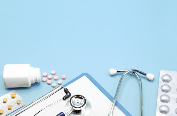 平坦的药片，药物，听诊器和书写垫回形针板，在浅蓝色的背景上拷贝空间，医疗保健和医疗概念，俯视图照片。图片下载