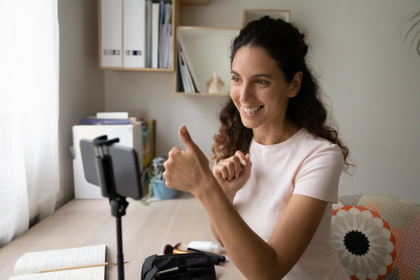 女子在智能手机上录制视频博客，显示竖起大拇指的手势图片下载