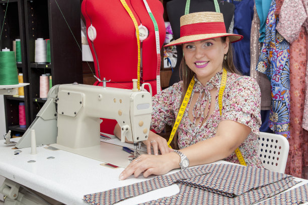 受启发的欧洲女裁缝在工作室的缝纫机上缝制衣服。图片下载
