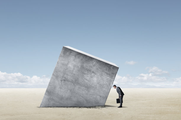 一名男子低头看着被卡在地面上的大混凝土块图片下载