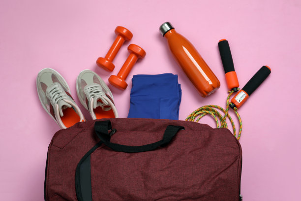 健身包和运动器材在浅粉红色的背景，平的铺设图片下载