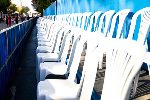 照片中的塑料椅子摆放在街道上，让人们可以坐着观看阿利坎特的游行。图片下载