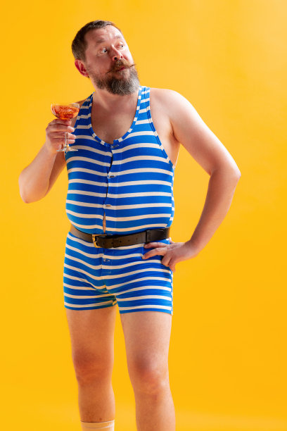 有趣的水手，胖胖的快乐的人穿着复古条纹泳衣在明亮的黄色背景上孤立地摆姿势。假期,夏季,幽默图片下载