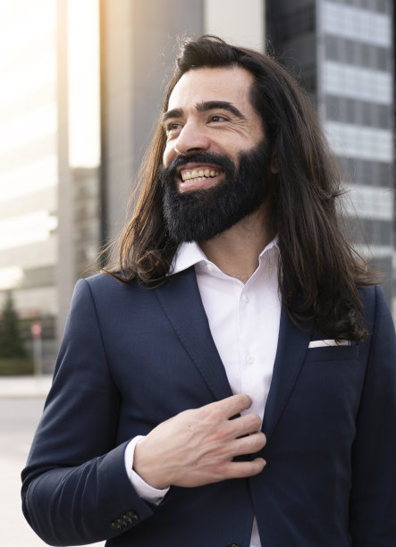 商人留着胡子和长发，在户外开心微笑图片下载