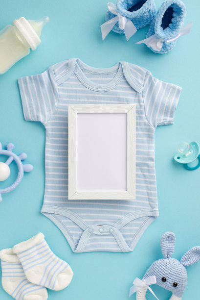 男婴的概念。俯视图垂直照片的紧身衣相框牙齿编织兔子拨浪鼓玩具袜子靴子奶瓶和奶嘴在孤立的粉彩蓝色背景与空白图片下载